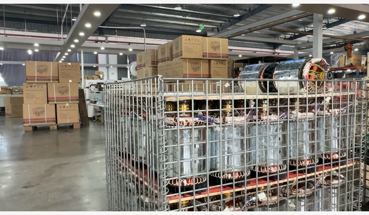 Multiple alternator assemblies held in a metal parts cage in a workshop